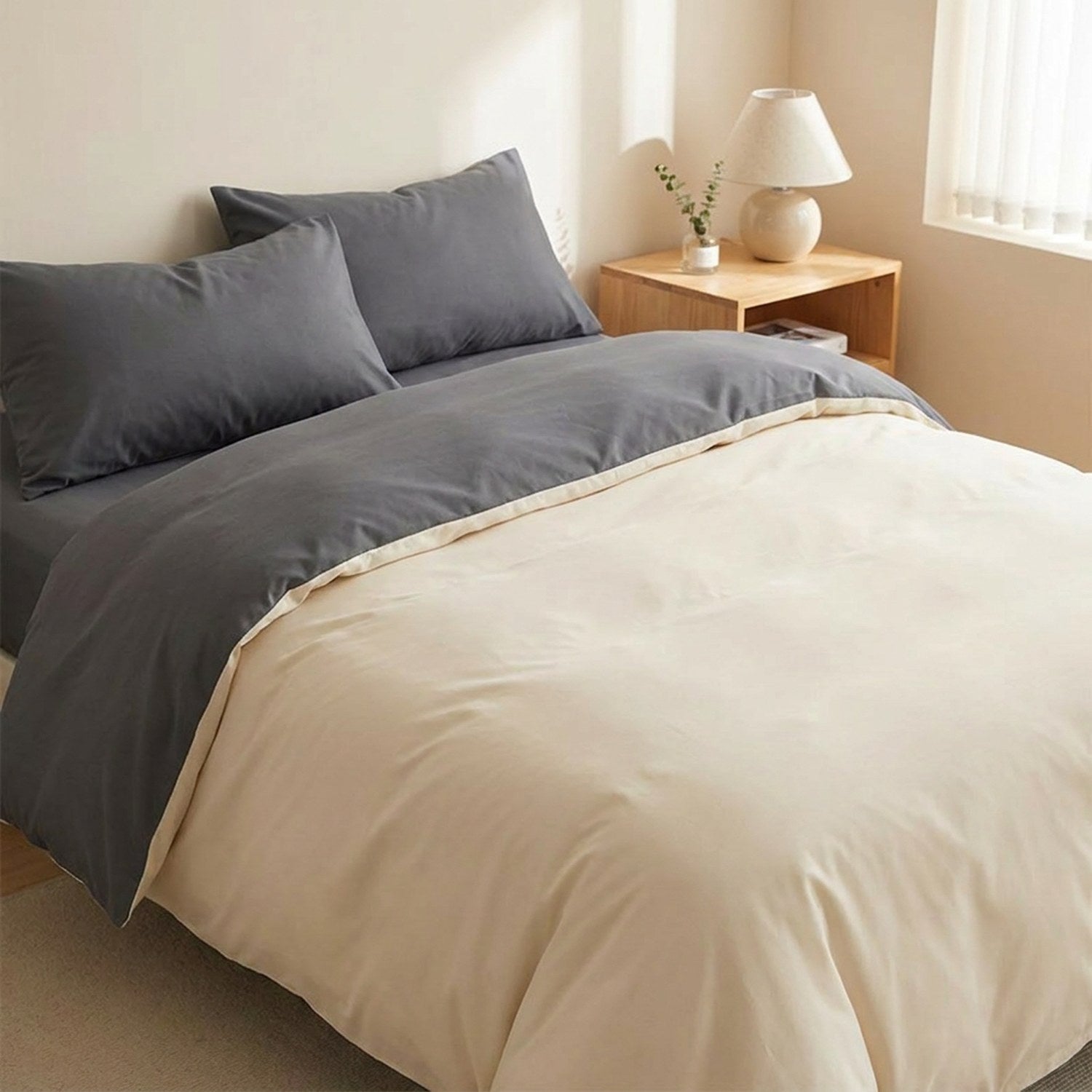 Parure de lit bicolore beige installée sur un lit fait dans une chambre apaisante