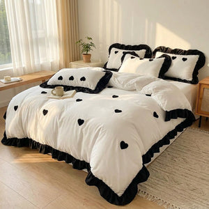 Parure de lit brodee coeur noir installee sur un grand lit dans une chambre lumineuse et cosy