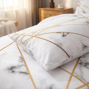 Détail du motif marbre blanc et lignes dorées de la parure de lit