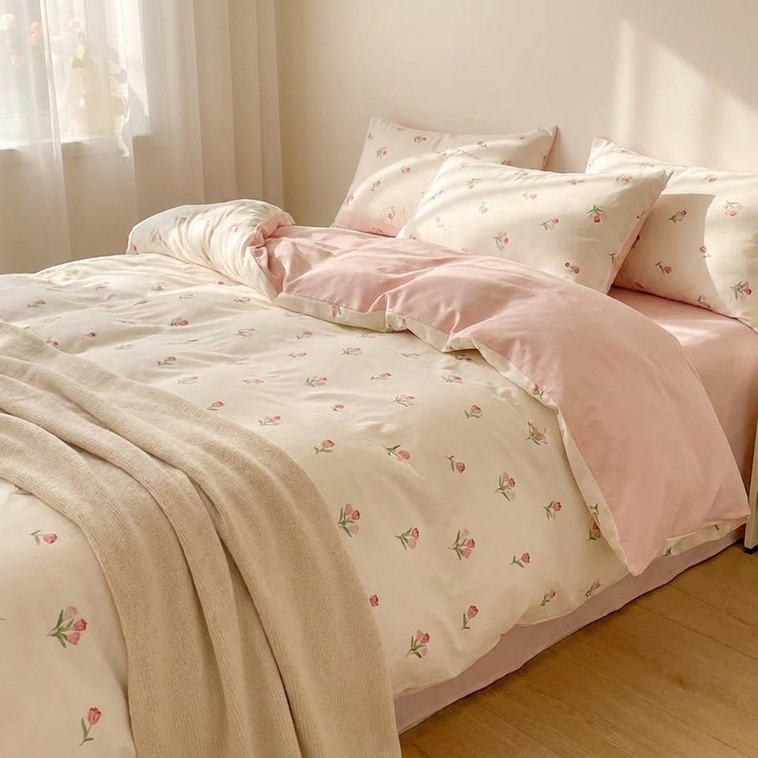 Parure de lit fleurie coton lavé aux tulipes roses vue de près dans une chambre cocooning
