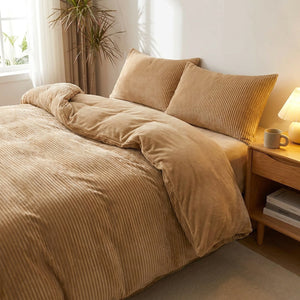 Parure de lit en velours côtelé beige installée sur un lit deux places