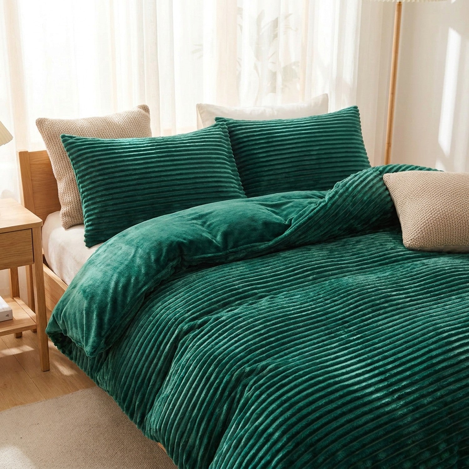 Parure de lit en velours vert sur un lit dans une chambre lumineuse et aérée