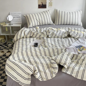 Une parure de lit rayures minimalistes posée sur un lit soigneusement arrangé avec deux taies assorties, un motif linéaire élégant créant une ambiance moderne et apaisante dans la chambre.