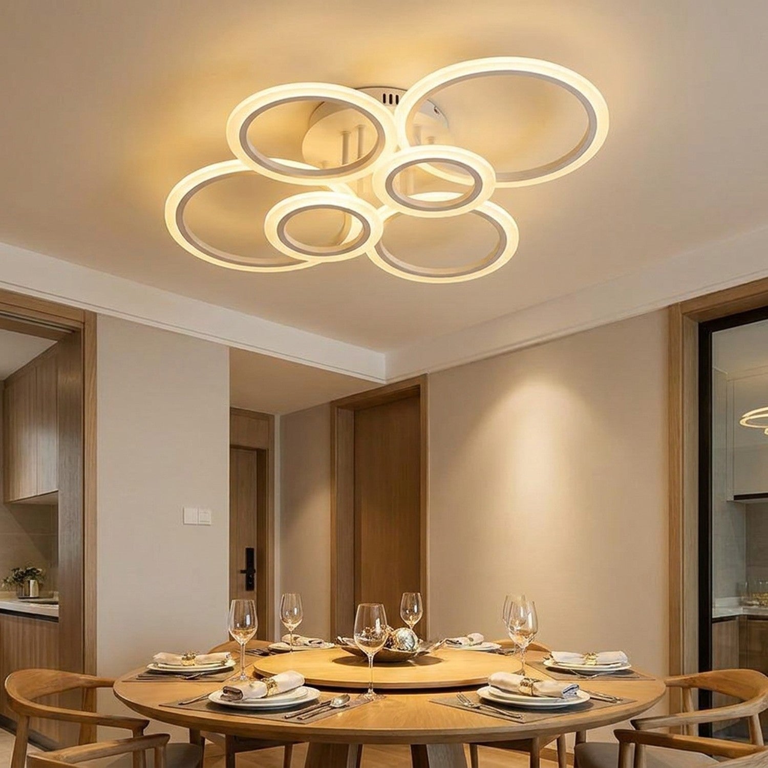 Plafonnier LED anneaux allumé au-dessus d'une table à manger en bois