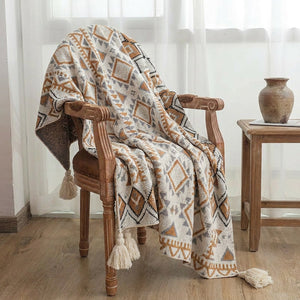 Plaid boho drapé sur un fauteuil en bois vintage près d une fenêtre