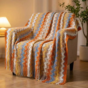 Plaid bohème à chevrons multicolores drapé sur un fauteuil lumineux