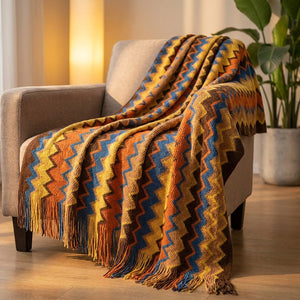 Plaid bohème à chevrons colorés orange drapé sur un fauteuil dans un salon chaleureux