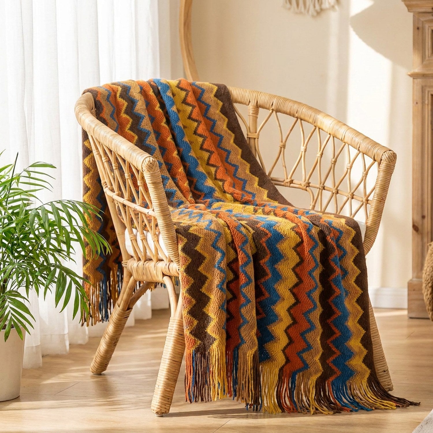 Plaid bohème à chevrons colorés orange drapé sur un fauteuil en rotin près d'une fenêtre