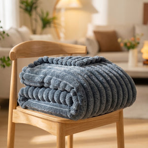 Plaid en flanelle épaisse à larges rayures beige posé sur un canapé dans un salon lumineux
