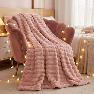 Plaid flanelle épaisse à larges rayures coloris rose sur fauteuil velours