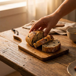 Planche bois acacia utilisée pour servir du pain sur table en bois