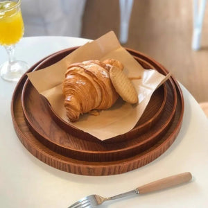 Trois plateaux ronds en bambou empilés avec croissant et petits gâteaux