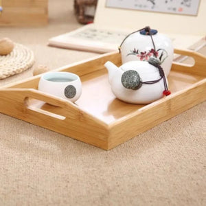 Plateau en bambou avec théière et tasses en céramique blanche