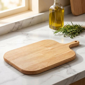 Plateau en bois naturel avec poignée posé sur comptoir en marbre avec herbes et huile d'olive