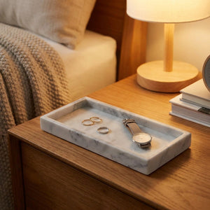 Plateau en marbre gris sur table de nuit avec bijoux et montre