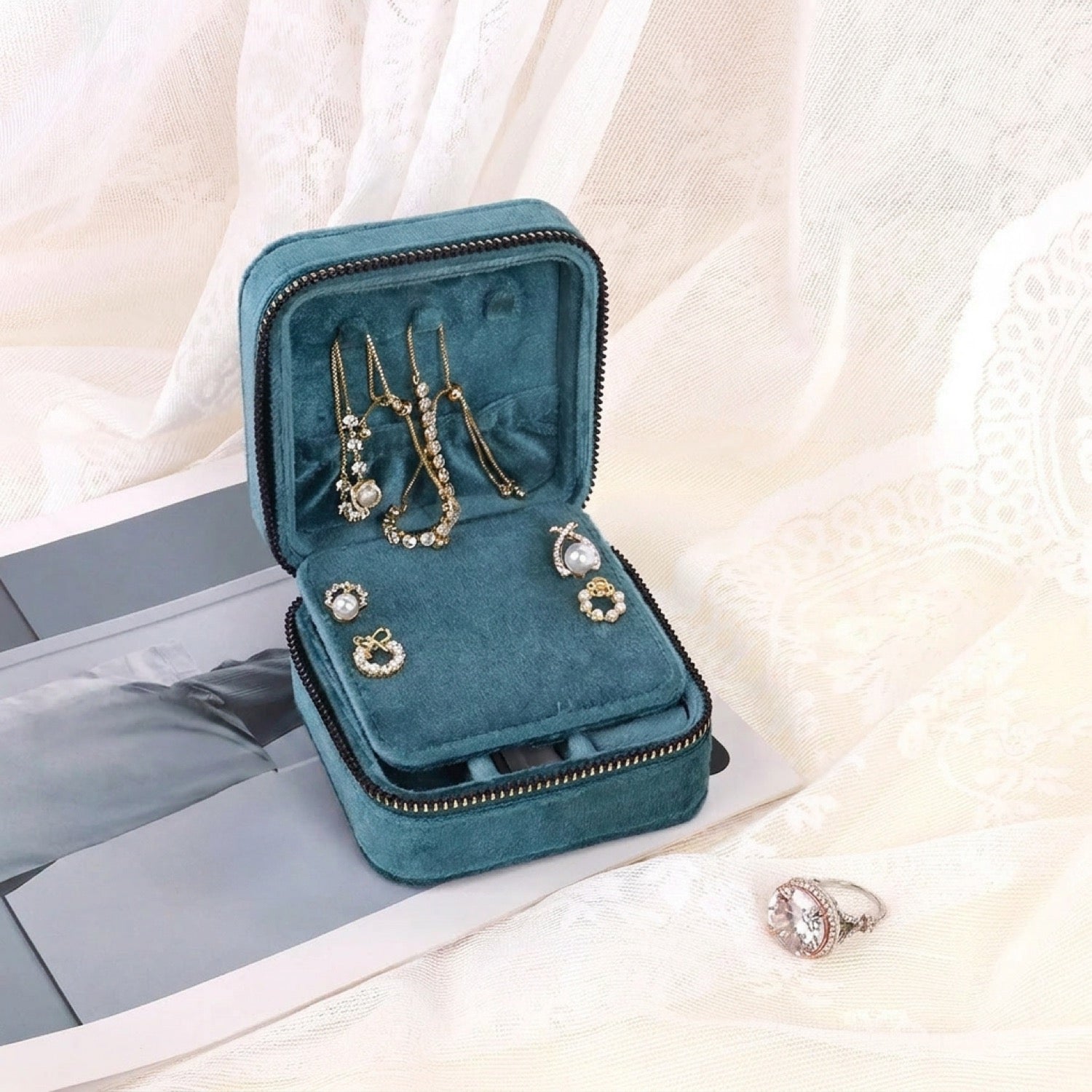 Boîte à bijoux bleu canard ouverte montrant des colliers et boucles d oreilles