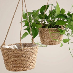 Deux pots suspendus en jute tressé avec plantes tropicales
