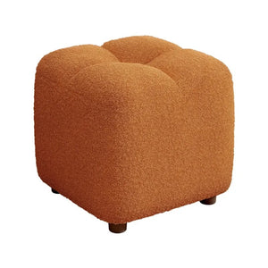 Pouf bouclé marron vu de face sur fond neutre