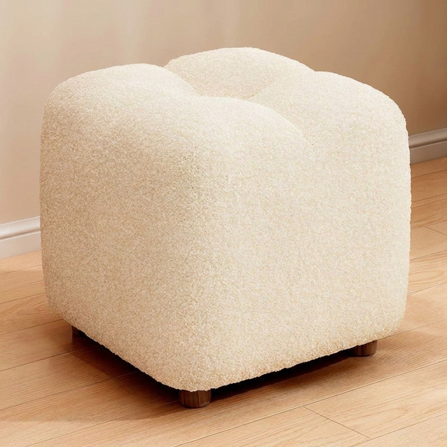 Pouf bouclé coloris blanc sur fond neutre chaleureux