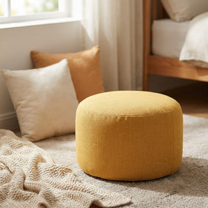 Pouf rond en lin jaune moutarde dans un coin lecture lumineux