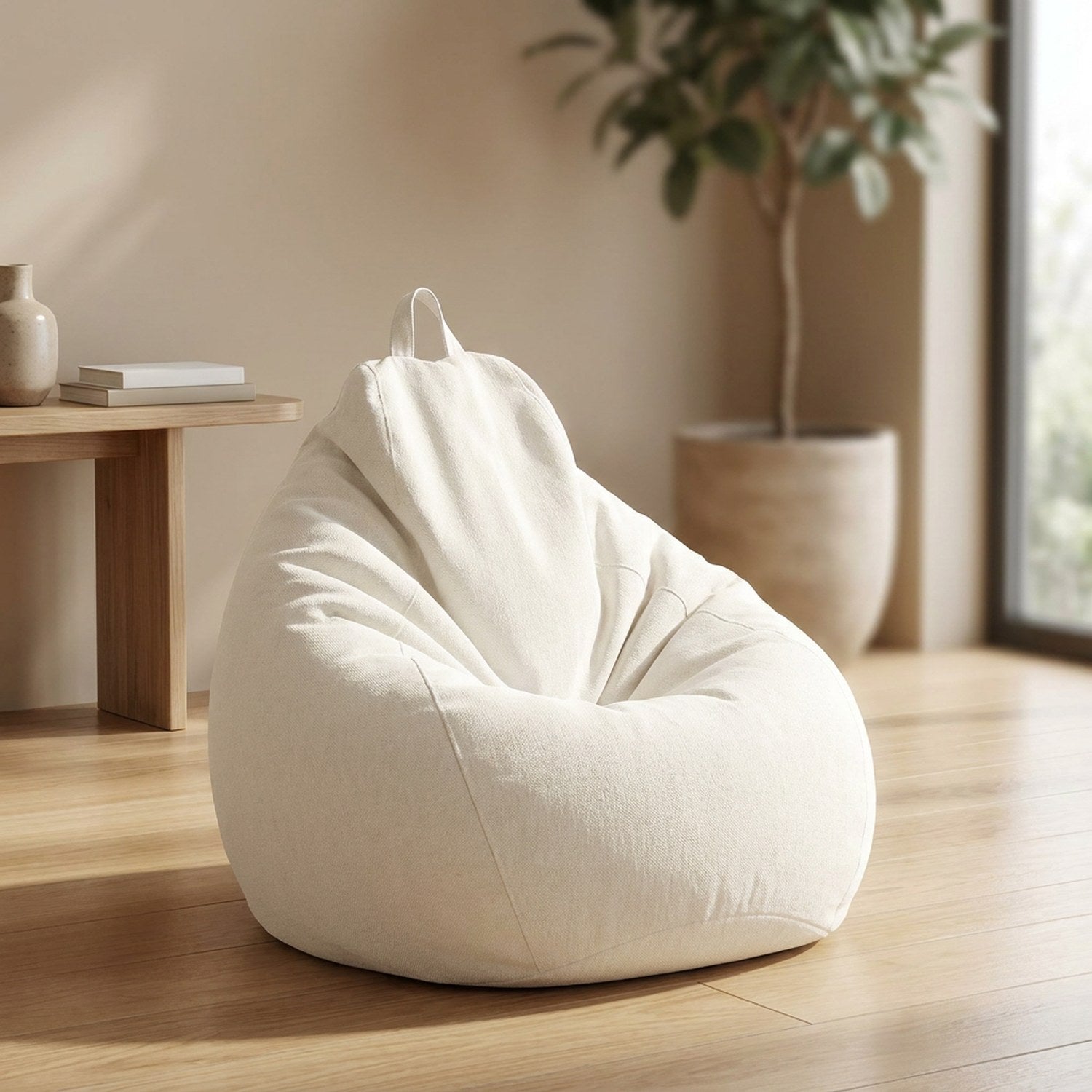 Pouf poire en coton et lin blanc cassé posé dans un salon lumineux avec plante et étagère