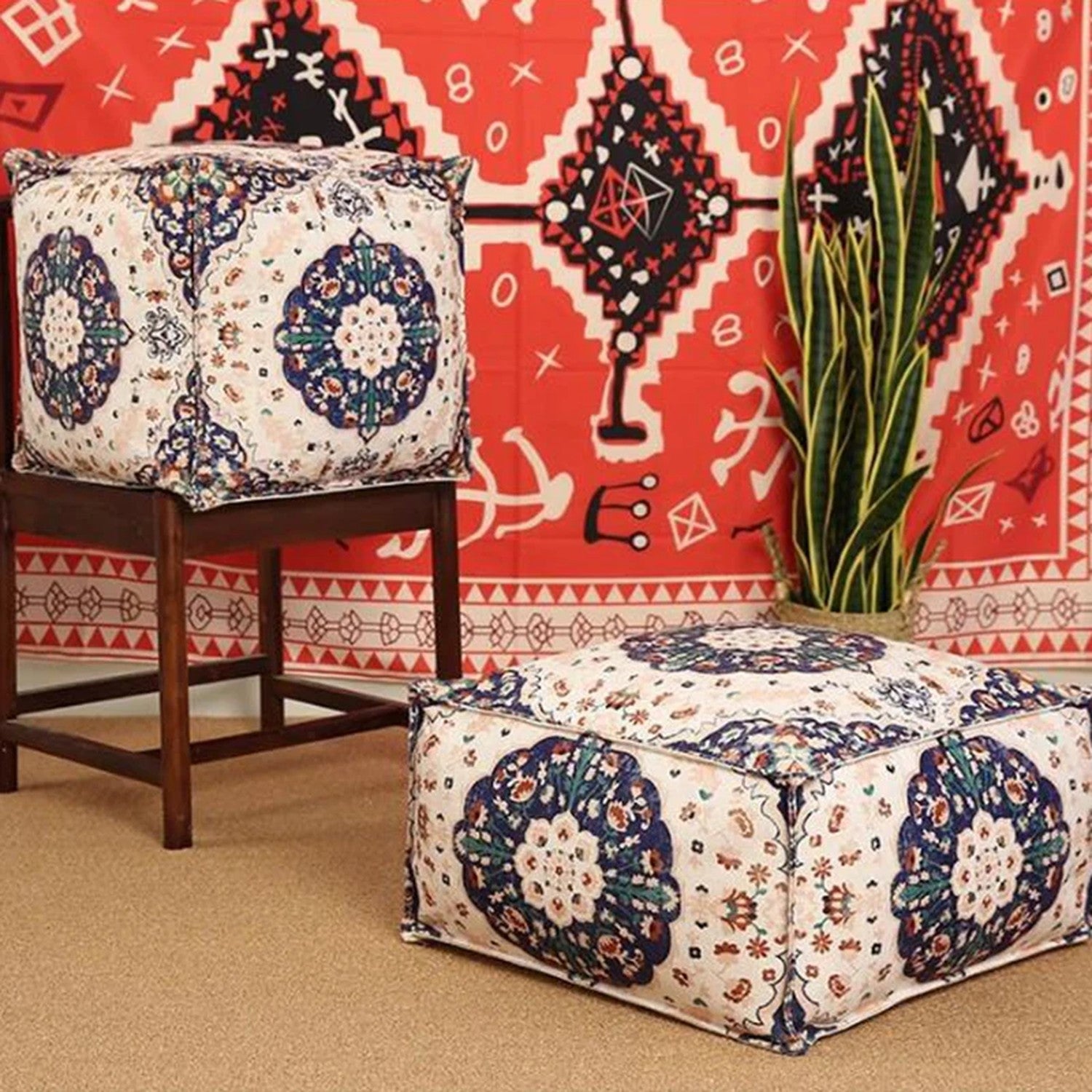 Housse de pouf marocain ivoire à motif floral bleu marine posée sur tapis berbère