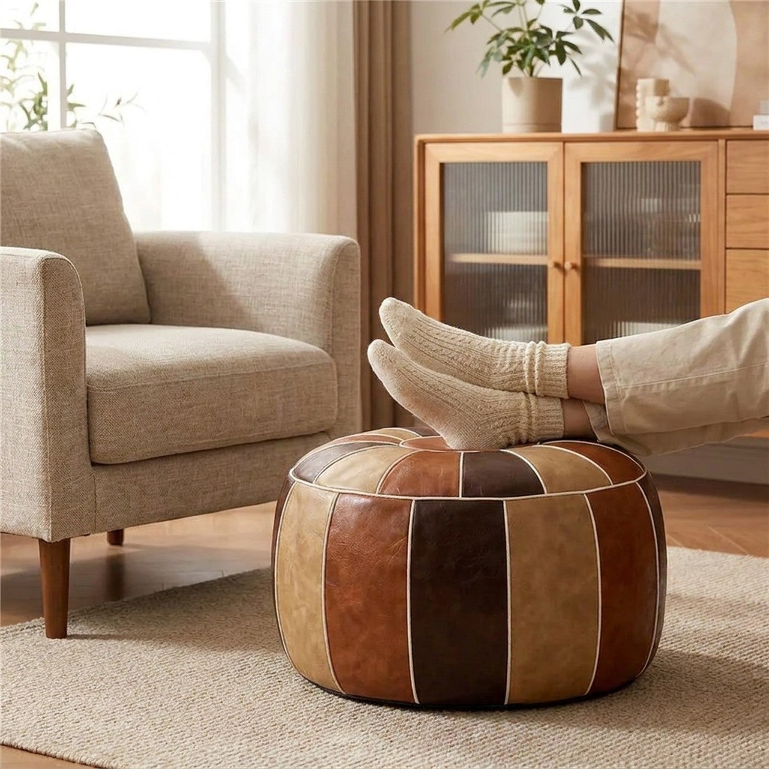 Pieds en chaussettes posés sur un pouf marocain patchwork devant un fauteuil beige