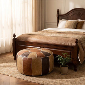 Pouf marocain patchwork posé sur un tapis au pied d'un lit dans une chambre chaleureuse