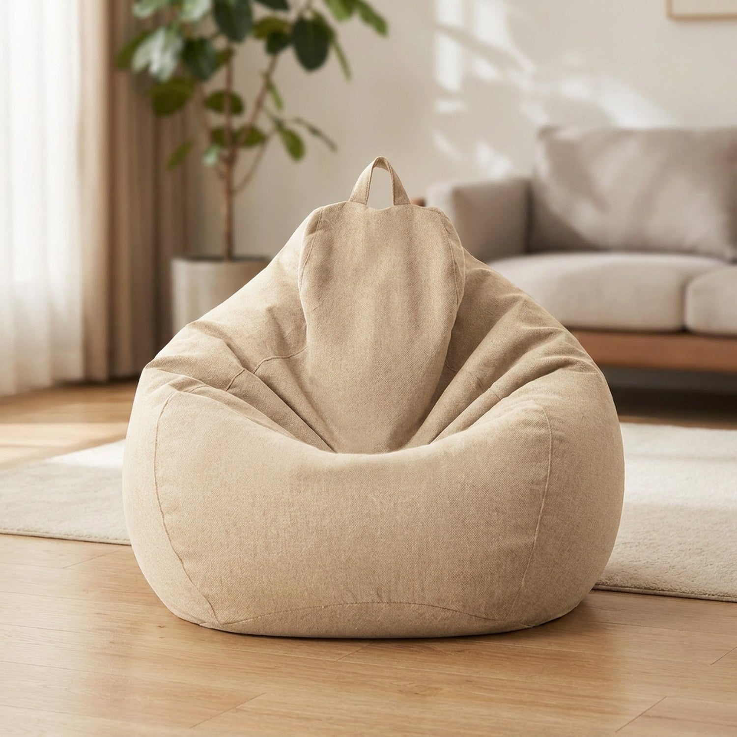 Pouf poire en coton lin beige moelleux posé au sol dans un salon chaleureux et lumineux