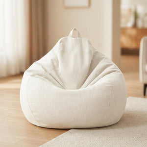 Pouf poire en coton lin blanche posé au sol dans un intérieur cosy