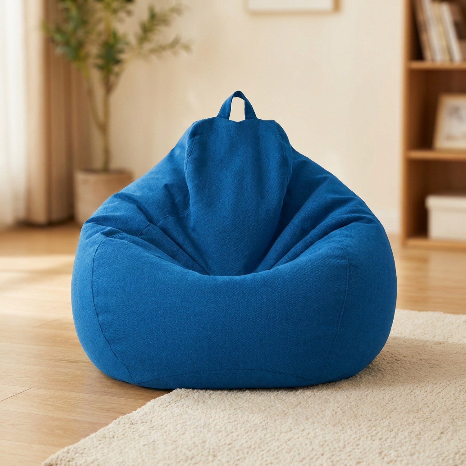 Pouf poire en coton lin bleu posé au sol dans un intérieur cosy