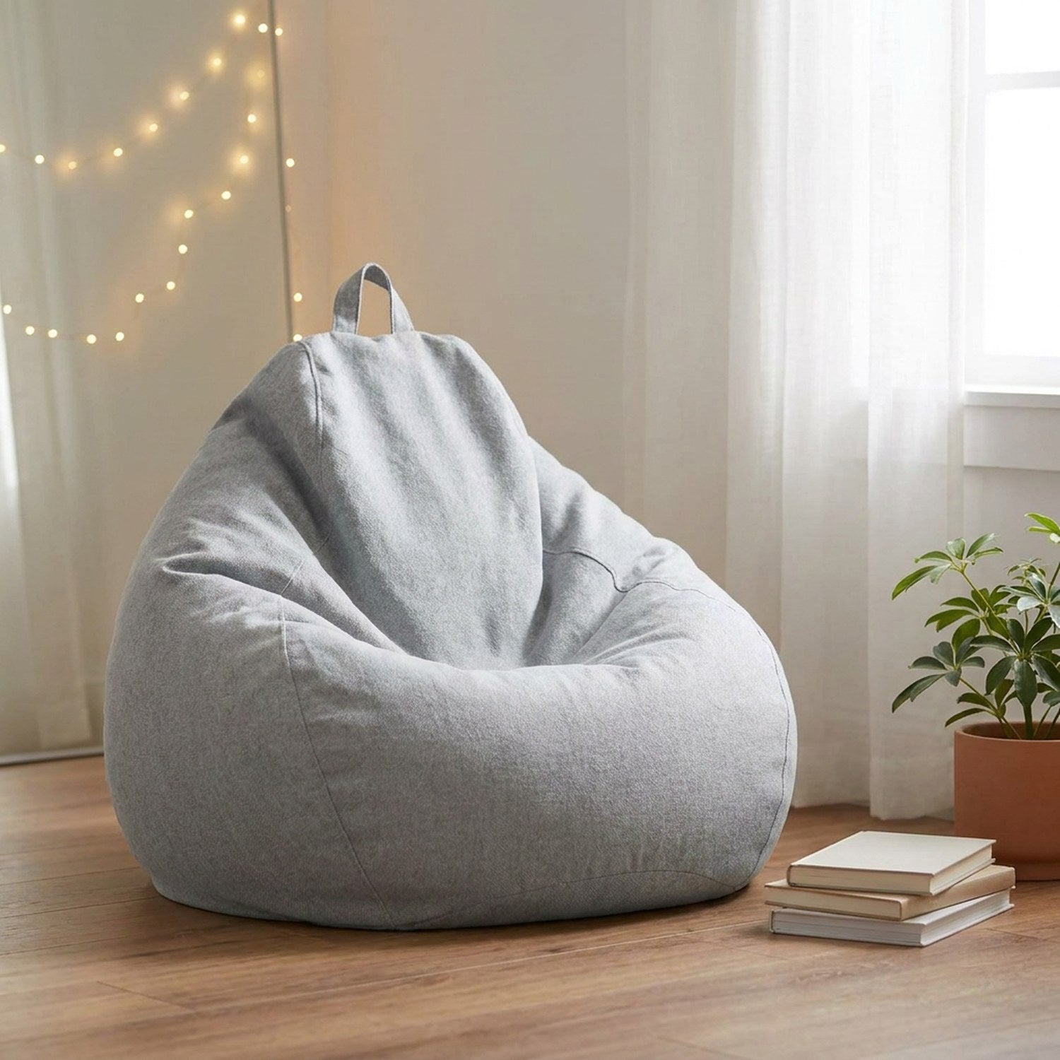 Pouf poire gris clair dans une chambre lumineuse avec guirlande lumineuse et livres