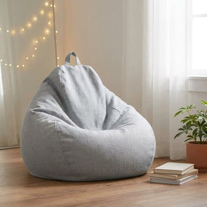 Pouf poire gris clair dans une chambre lumineuse avec guirlande lumineuse et livres
