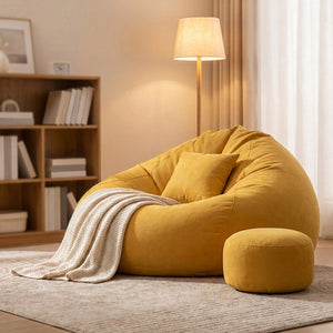 Pouf géant fauteuil poire jaune en coin lecture dans une chambre avec lampe et plaid