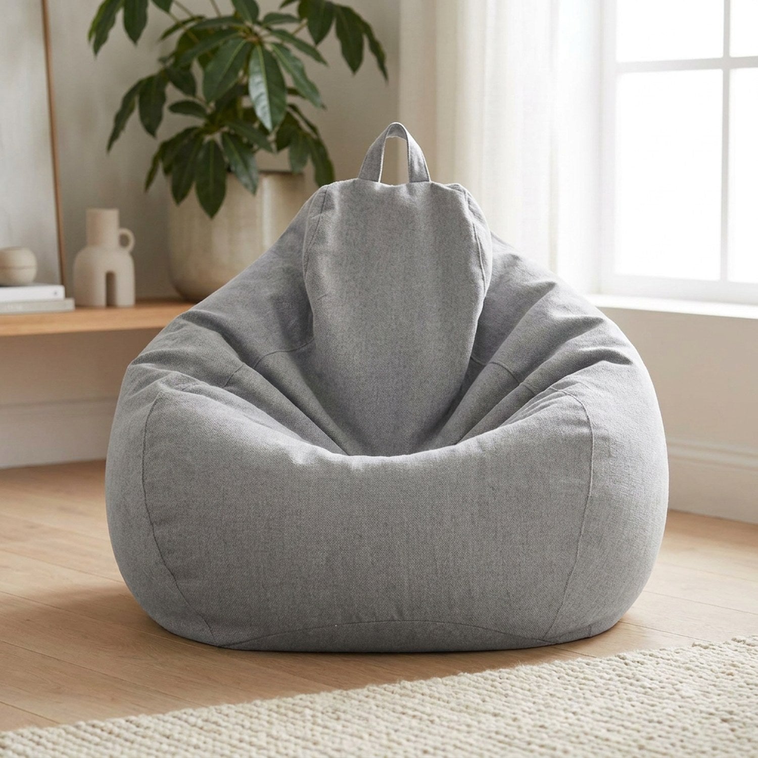 Pouf géant en coton lin gris clair en forme de poire posé sur le sol d un salon lumineux