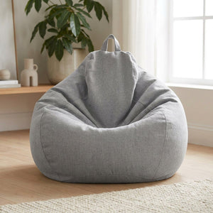 Pouf géant en coton lin gris clair en forme de poire posé sur le sol d un salon lumineux