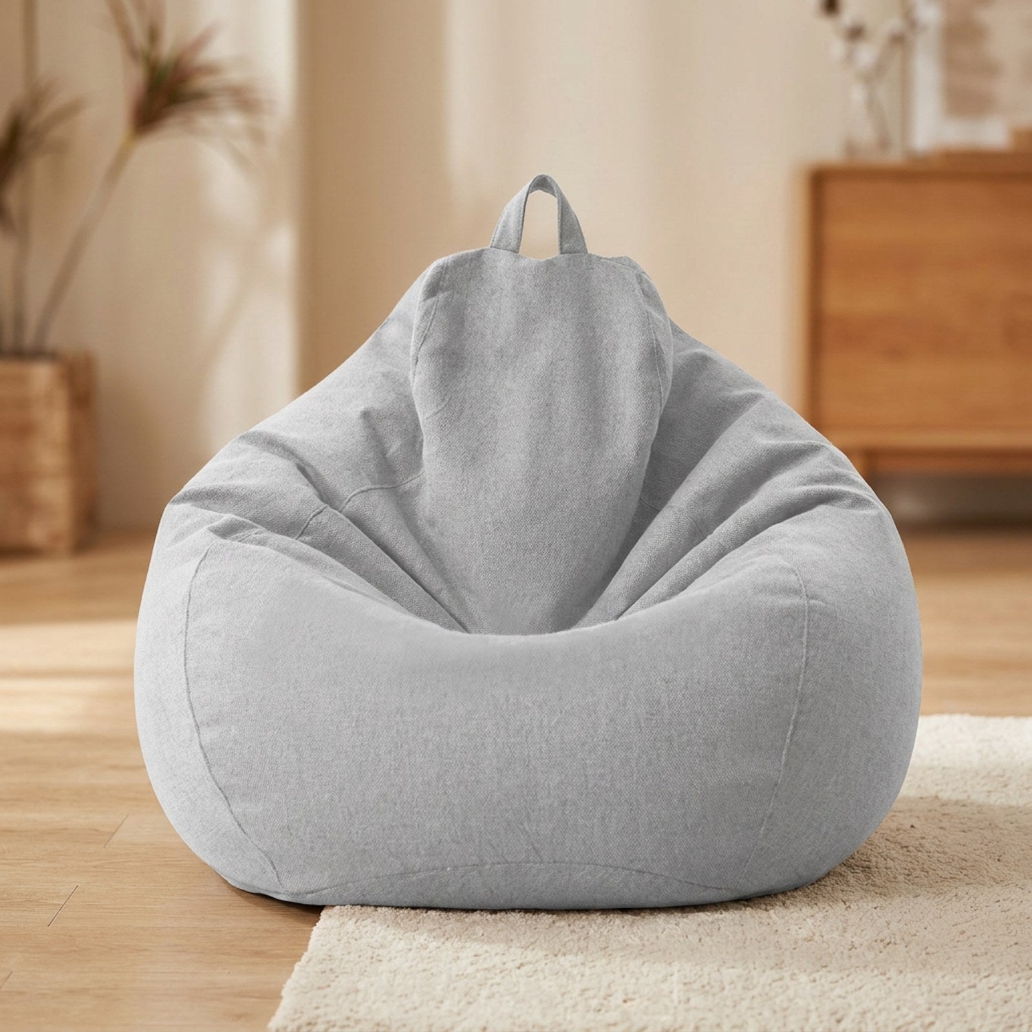 Pouf poire en coton lin gris posé au sol dans un intérieur cosy