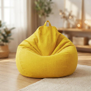 Pouf poire en coton lin jaune posé au sol dans un intérieur cosy
