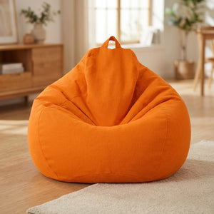 Pouf poire en coton lin orange posé au sol dans un intérieur cosy