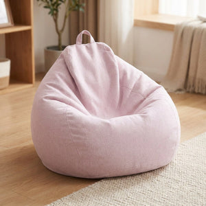 Pouf poire en coton lin rose posé au sol dans un intérieur cosy