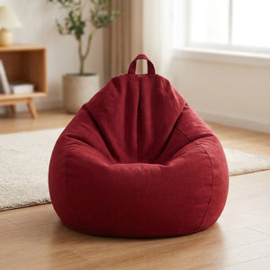 Pouf poire en coton lin rouge posé au sol dans un intérieur cosy