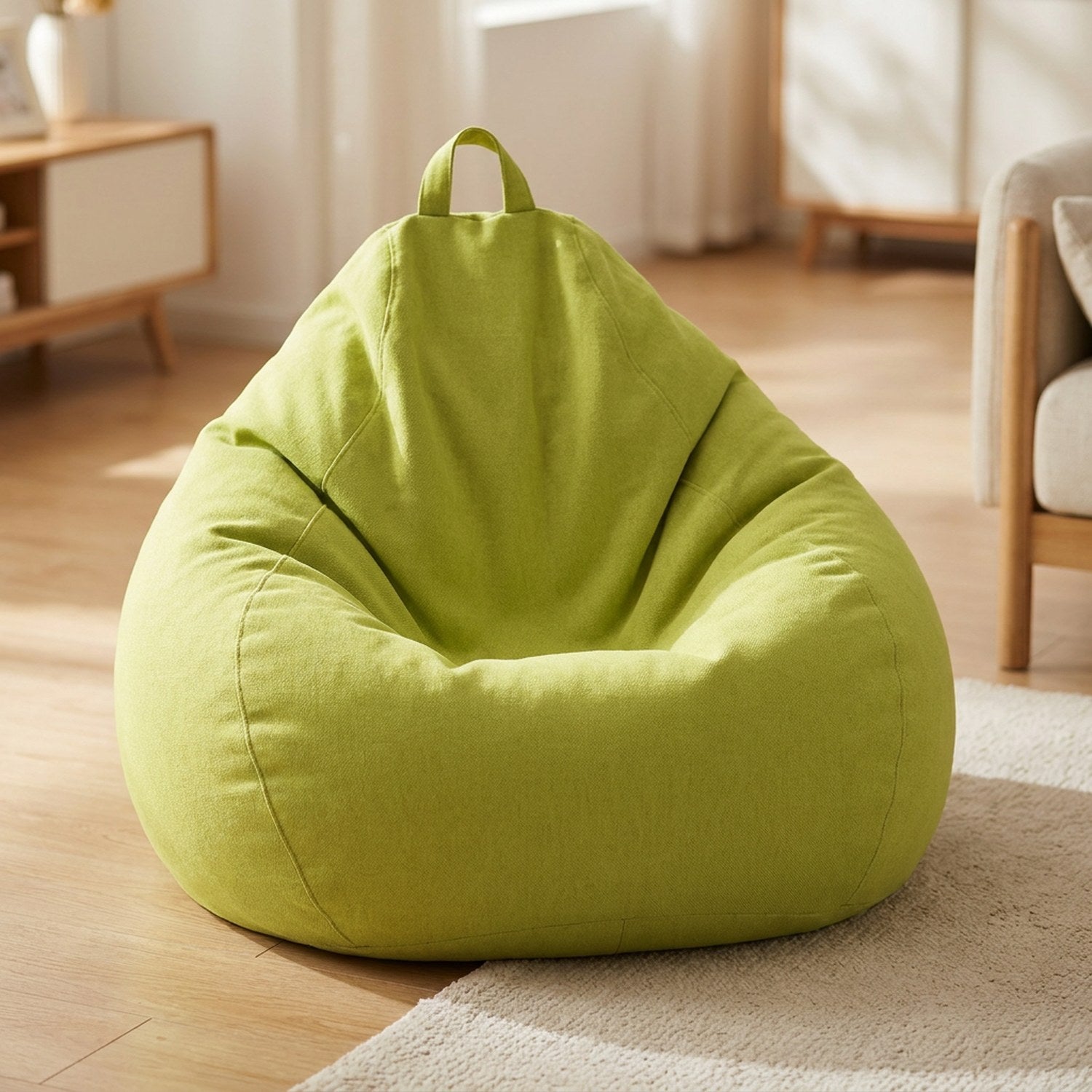 Pouf poire en coton lin verte posé au sol dans un intérieur cosy