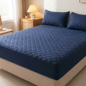 Protège matelas imperméable matelassé bleu marine installé sur un lit