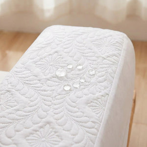 Gros plan sur le protège-matelas blanc matelassé avec des gouttes d'eau qui perlent en surface