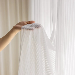 Détail du voilage en tulle blanc montrant les fines rayures verticales et la transparence
