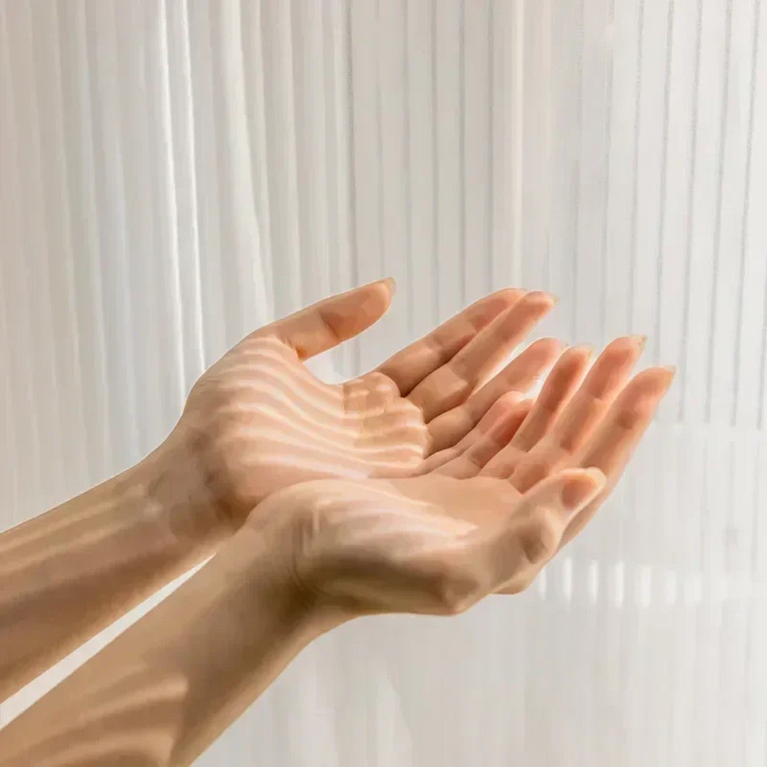Main derrière le voilage transparent illustrant la légèreté et la translucidité du tulle