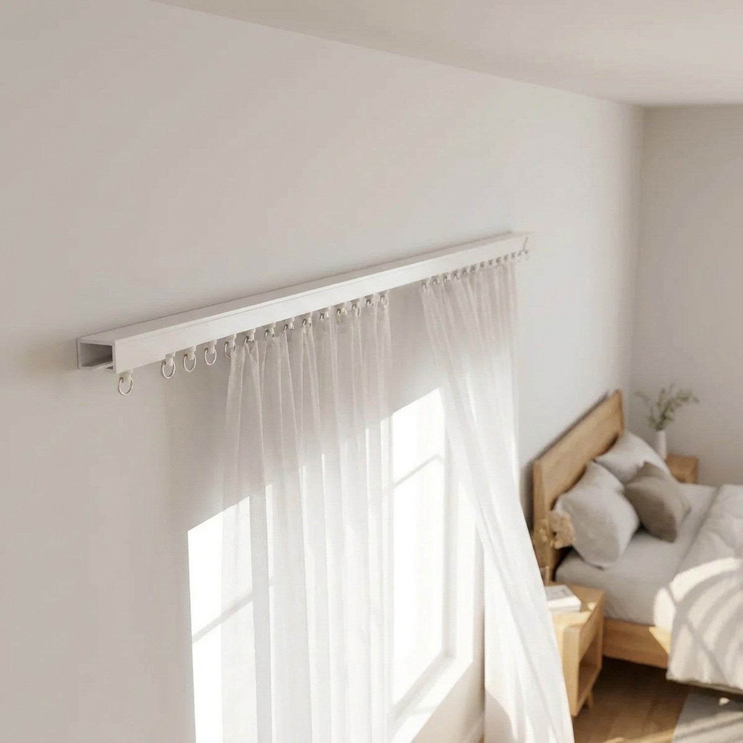 Rail de rideau blanc fixé au mur d'une chambre avec voilage blanc