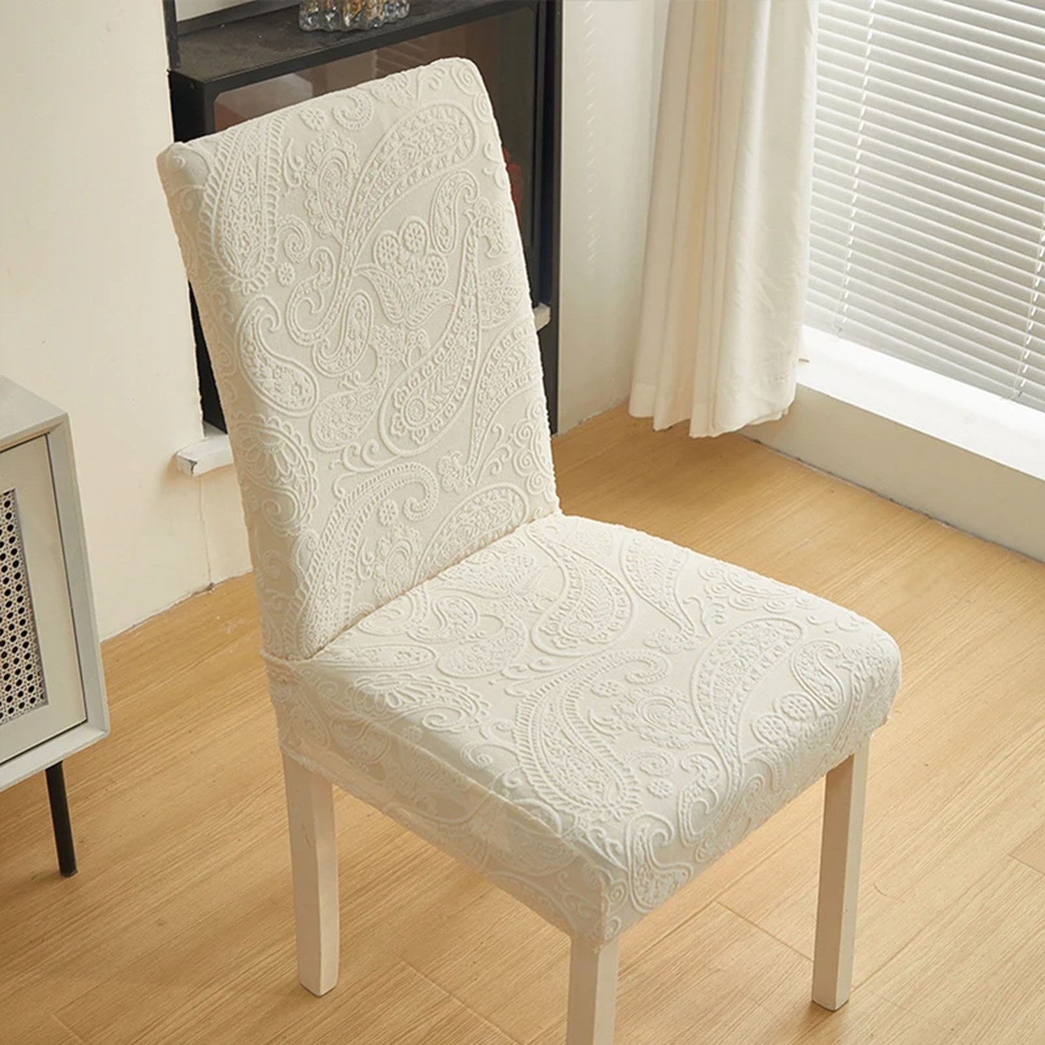 Housse de chaise beige à motif jacquard en relief installée sur une chaise
