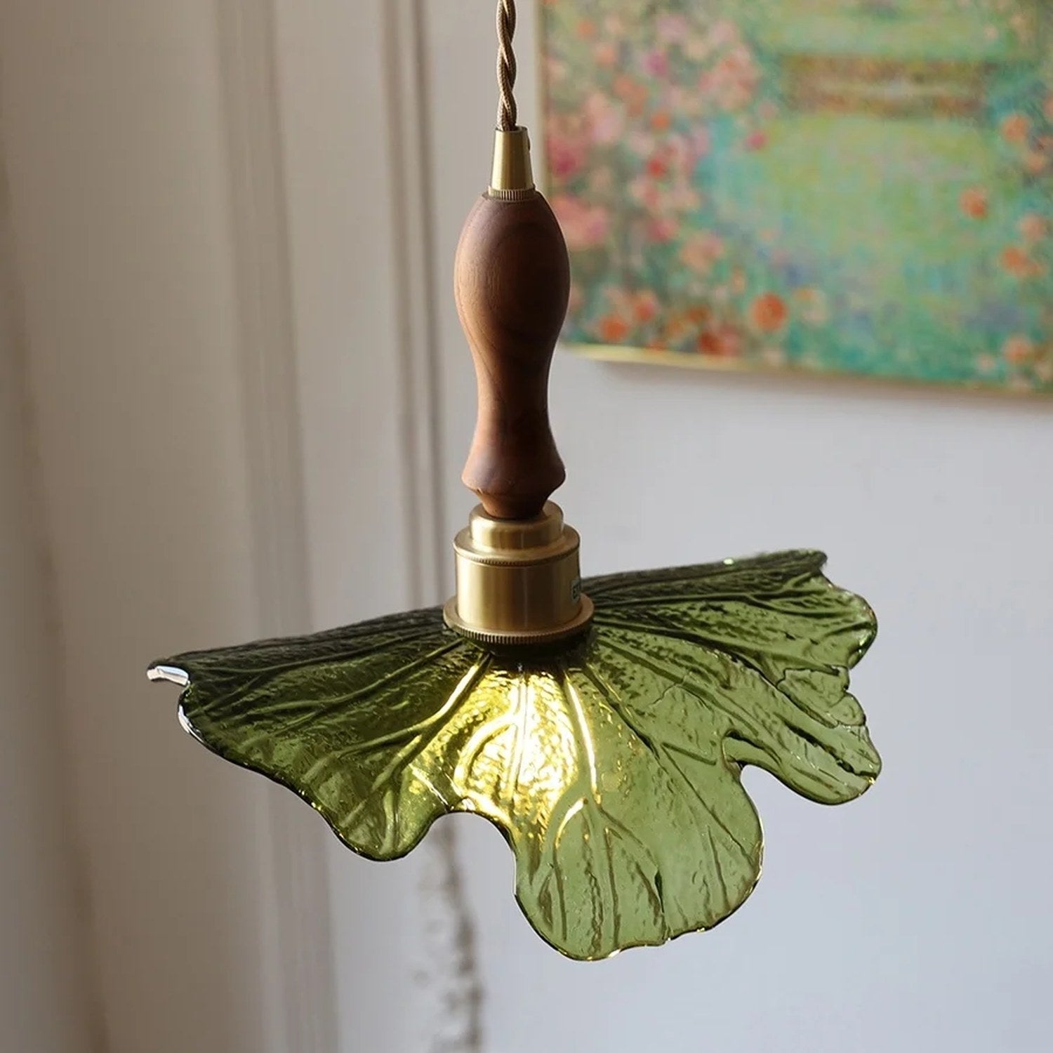 Détail de l'abat-jour en verre vert nervuré et de la douille en laiton