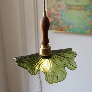 Détail de l'abat-jour en verre vert nervuré et de la douille en laiton